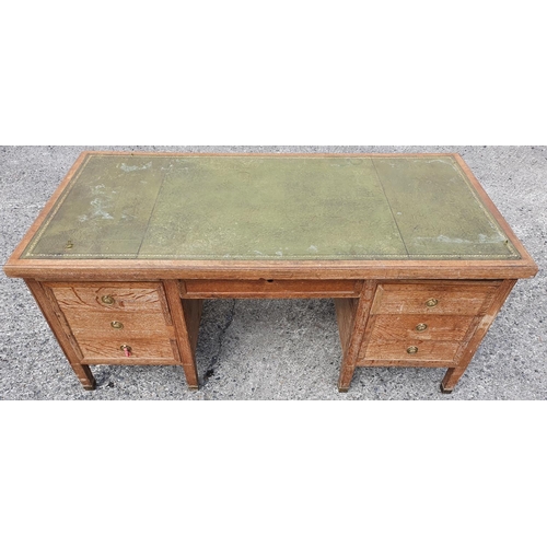 1052 - A limed Oak kneehole twin Pedestal Desk with inset green leather panelled top over an arrangement of... 