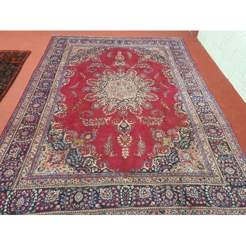 1041 - A large vintage Persian Kerman Carpet with red ground and a central medallion design. Some wear and ... 