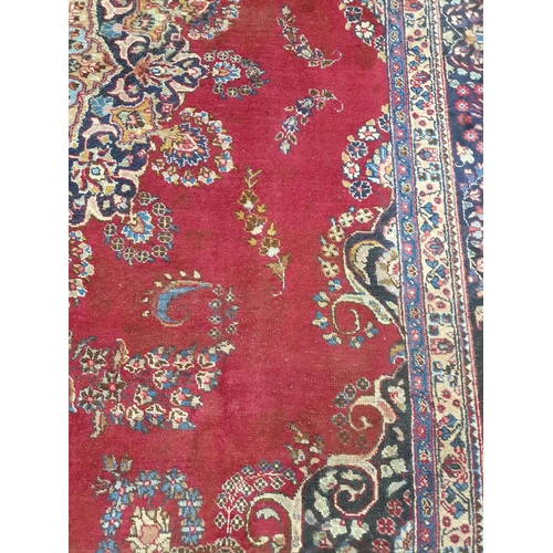 1041 - A large vintage Persian Kerman Carpet with red ground and a central medallion design. Some wear and ... 