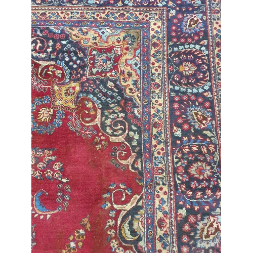 1041 - A large vintage Persian Kerman Carpet with red ground and a central medallion design. Some wear and ... 