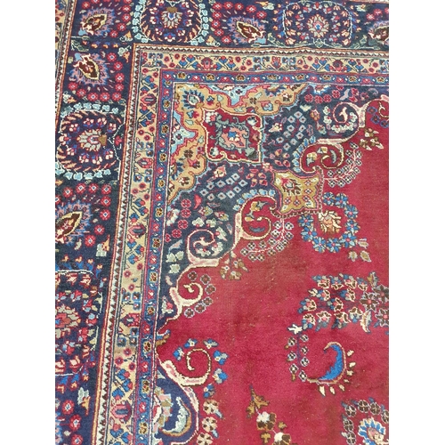 1041 - A large vintage Persian Kerman Carpet with red ground and a central medallion design. Some wear and ... 