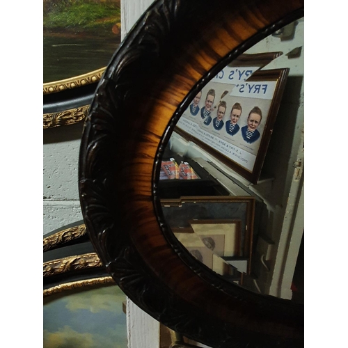 578 - An early 20th Century Grained Oval Mirror with a highly moulded outline and bevelled edge glass. 80W... 