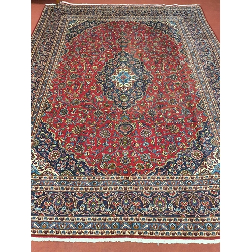 874 - A fantastic Large and hand woven red ground Iranian Carpet from the Kashan region with an medallion ... 