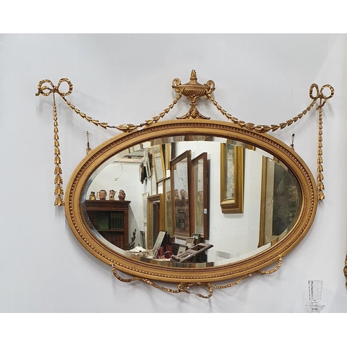 1010 - A 19th Century oval gilt Mirror with bell swags and bevelled glass. (Some faults). 90 x 70 cms appro... 