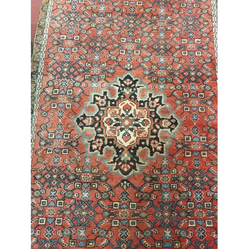 326 - A Persian red ground Carpet.295x120 cms approx.