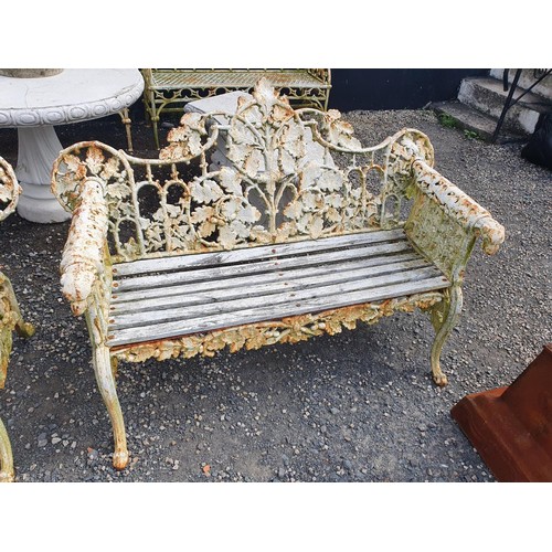 385 - A really good heavy cast Iron Garden Bench with oak leaf scroll design and dogs head arms.