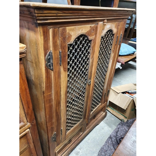 243 - A large hardwood two door Cabinet with grill front. 98W x 65D x 130H cms approx.