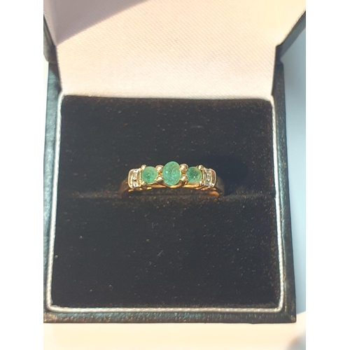 309 - Emerald and diamond band ring, stamped 18K, ring size M, 1.5gms.