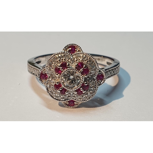 311 - An 18ct gold diamond and ruby cluster ring. Total ruby weight 0.16ct.Total diamond weight 0.39ct.Hal... 