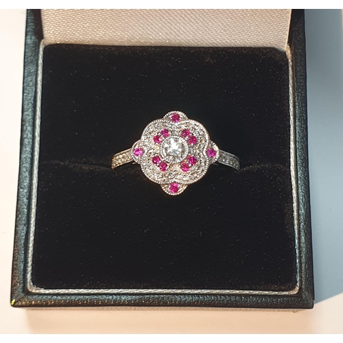 311 - An 18ct gold diamond and ruby cluster ring. Total ruby weight 0.16ct.Total diamond weight 0.39ct.Hal... 