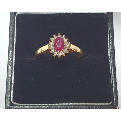 318 - An 18ct gold ruby and diamond cluster ring. Estimated total diamond weight 0.15ct. Hallmarks for 18c... 