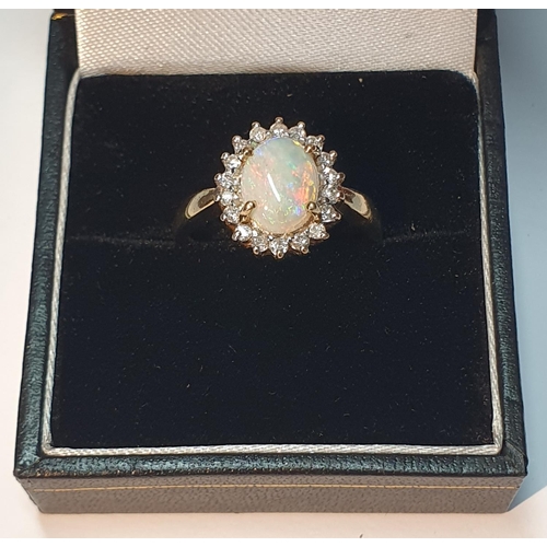 319 - A 9ct gold opal and brilliant-cut diamond cluster ring. Estimated total diamond weight 0.20ct. Hallm... 