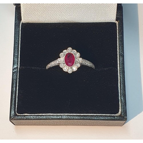 321 - An 18ct gold ruby and diamond cluster ring. Ruby weight 0.41ct. Total diamond weight 0.16ct. Hallmar... 