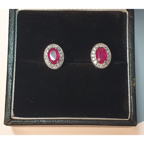 322 - A pair of 18ct gold ruby and diamond earrings. Total ruby weight 1.24cts. Total diamond weight 0.19c... 