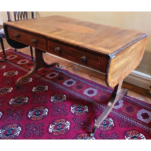 69 - A Regency Mahogany Sofa Table with an oval crossbanded top on twin splayed supports and with brass c... 