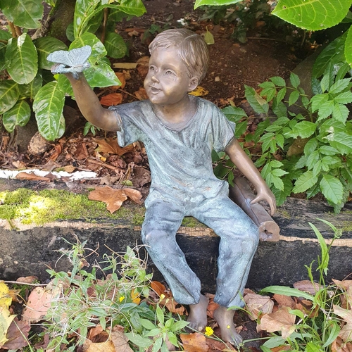 750 - A really good Bronze Figure of a Boy holding a Butterfly. L51cm approx.