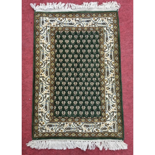 172 - A good heavy pile Green ground Rug. 102 x 61 cm approx.