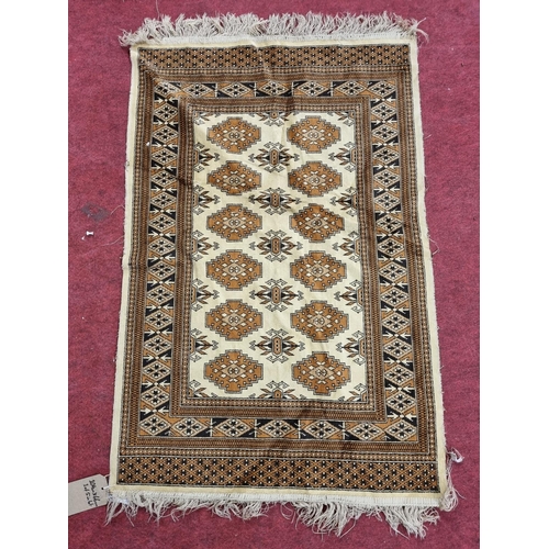 173 - A light cream ground Rug. 116 x 68 cm approx.