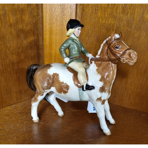 724 - A Beswick Pony with rider. H 14 cm approx.