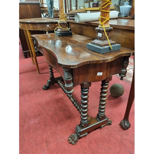 63 - A Regency Rosewood Library Table with serpentine outline turned stretcher base and hairy paw feet. H... 