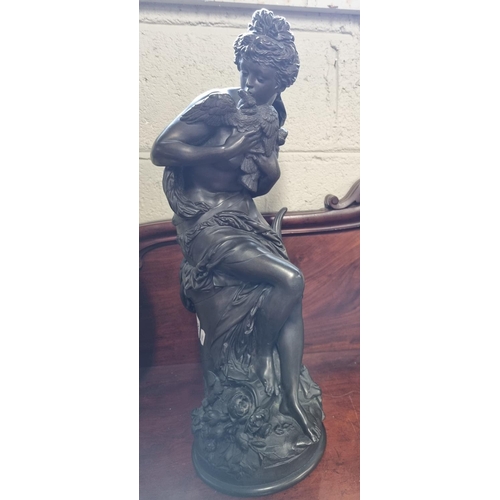 100 - After Carrier Relleiue. A semi naked Bronze figure of a girl holding a dove. H 60 cm approx.