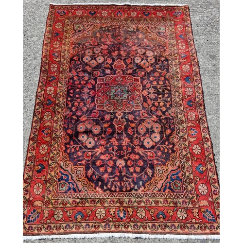 819 - A Blue ground ground Persian village Rug with a medallion design. 207 x 138 cm approx.