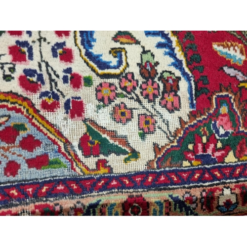 828 - A rich ground Persian Tabriz Carpet with a milticolour ground and a navy blue border. 395 x 270 cms ... 