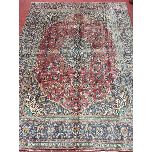 829 - A multicoloured Persian Kashan Carpet with a traditional floral medallion design. 387 x 293 cms appr... 