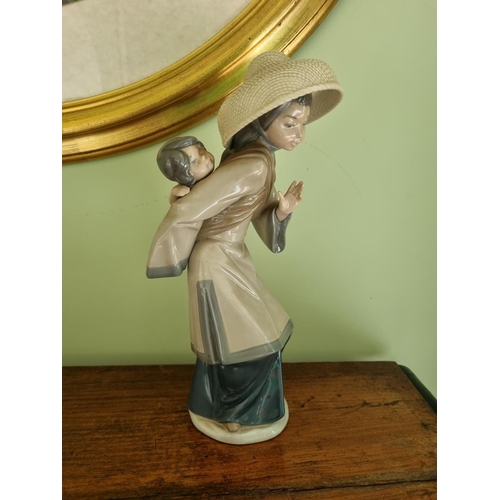 66 - A Lladro figure of an Oriental Woman and her child. H 27 cm approx.