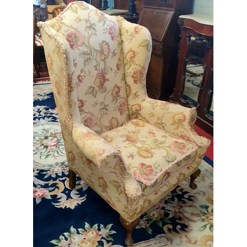 68 - A large wing back Armchair upholstered in beige and red floral fabric on cabriole supports.
W 88 x S... 