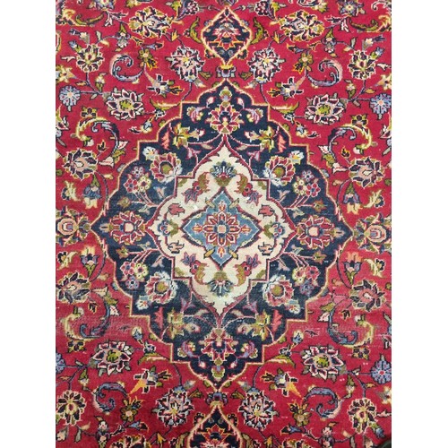 853 - A red ground Persian Rug with unique medallion design. 258 x 130 cms approx.