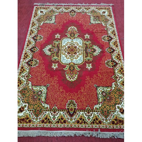858 - A Red ground Carpet with Cream and Green tones. 290 x 200 cms approx.
