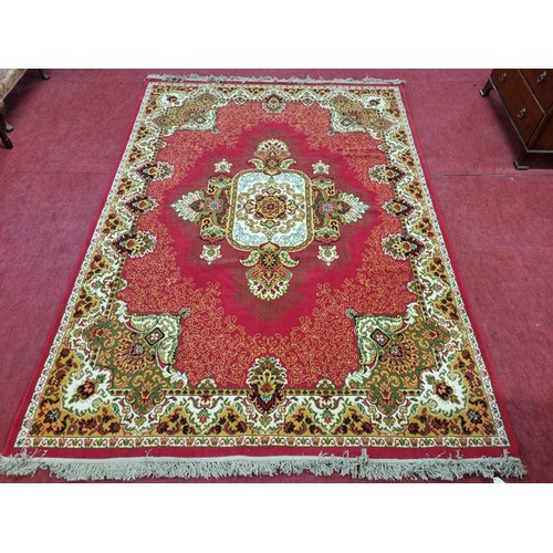 858 - A Red ground Carpet with Cream and Green tones. 290 x 200 cms approx.