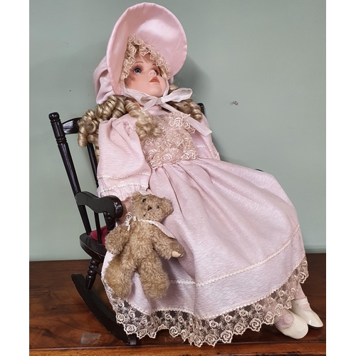 588 - A Porcelain Doll in a rocking chair along with three other porcelain dolls.