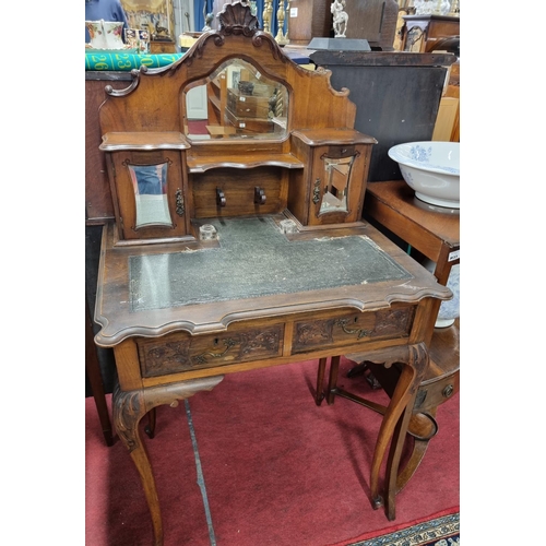 1032 - An Edwardian carved Mahogany ladies Writing Desk with a mirrored back 2 small drawers on cabriole le... 