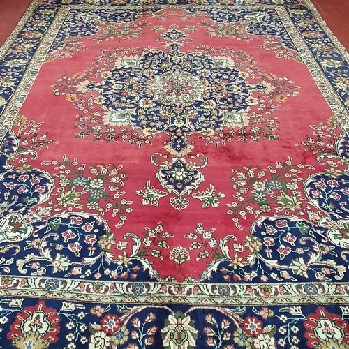 753 - A Red/Deep Pink ground Persian Marshad Carpet with a floral medallion design. 386 x 290 cm approx.