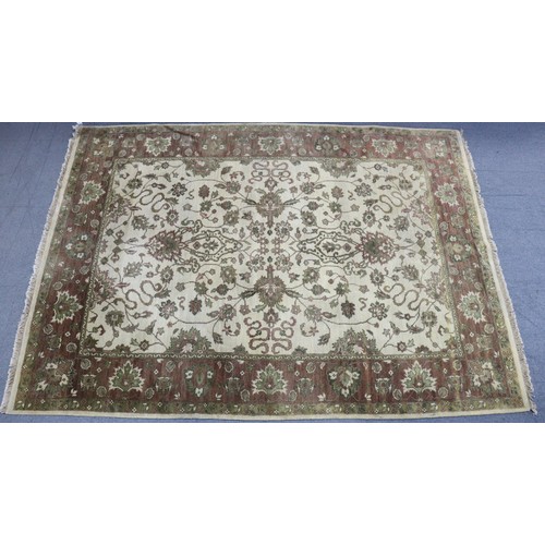 606a - An Indian Cream ground Rug with all-over repeating multi-coloured geometric design.