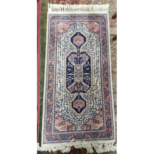 471 - A cream ground Rug with multi borders and central design decoration. 144 x 68 cm approx.