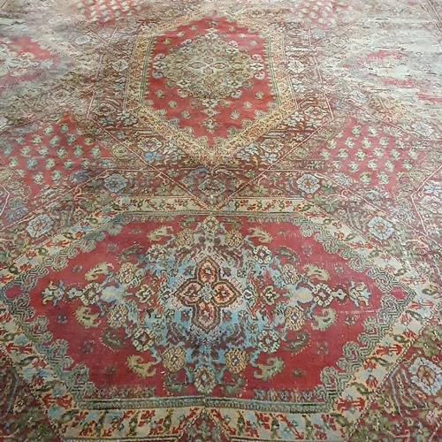 470 - An extremely large Carpet with green and red ground and allover decoration. (quite badly worn). 400 ... 