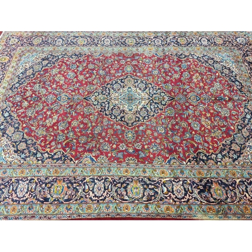 770 - A large fine woven Iranian Carpet from the Kashan region with a red field surrounded with a triple b... 