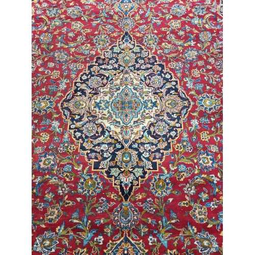 770 - A large fine woven Iranian Carpet from the Kashan region with a red field surrounded with a triple b... 