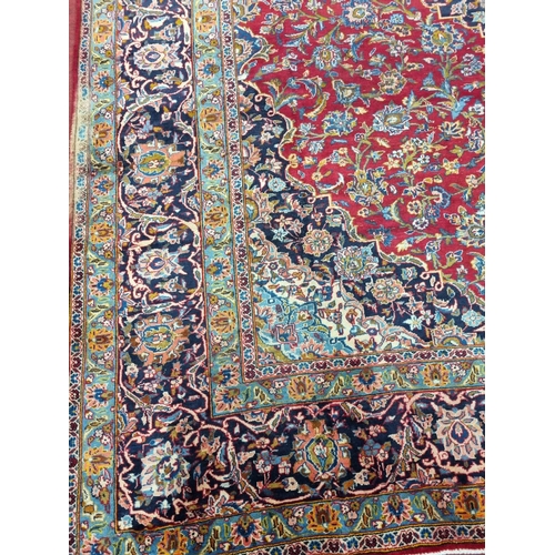 770 - A large fine woven Iranian Carpet from the Kashan region with a red field surrounded with a triple b... 