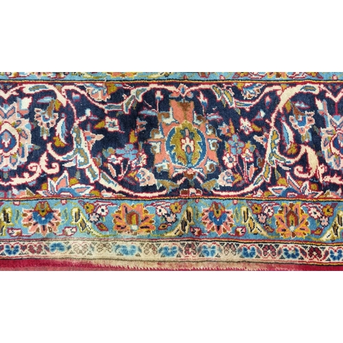 770 - A large fine woven Iranian Carpet from the Kashan region with a red field surrounded with a triple b... 