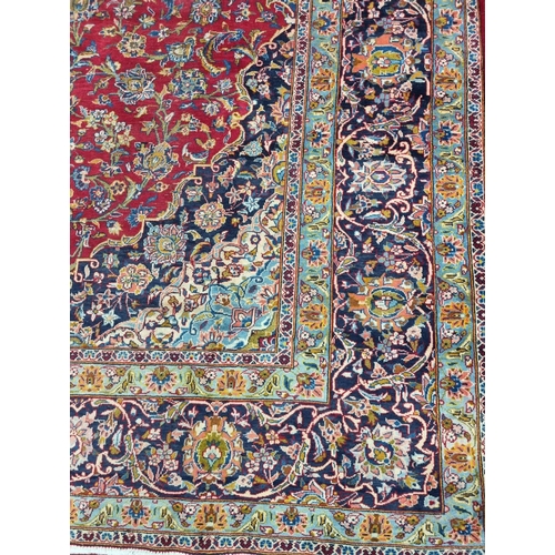 770 - A large fine woven Iranian Carpet from the Kashan region with a red field surrounded with a triple b... 