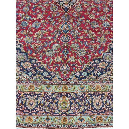 770 - A large fine woven Iranian Carpet from the Kashan region with a red field surrounded with a triple b... 