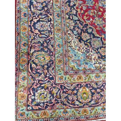 770 - A large fine woven Iranian Carpet from the Kashan region with a red field surrounded with a triple b... 