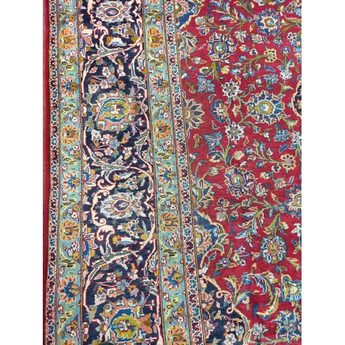 770 - A large fine woven Iranian Carpet from the Kashan region with a red field surrounded with a triple b... 