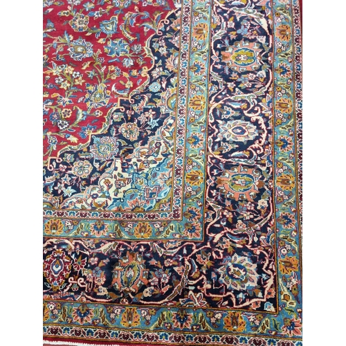 770 - A large fine woven Iranian Carpet from the Kashan region with a red field surrounded with a triple b... 