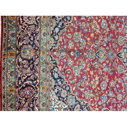 770 - A large fine woven Iranian Carpet from the Kashan region with a red field surrounded with a triple b... 