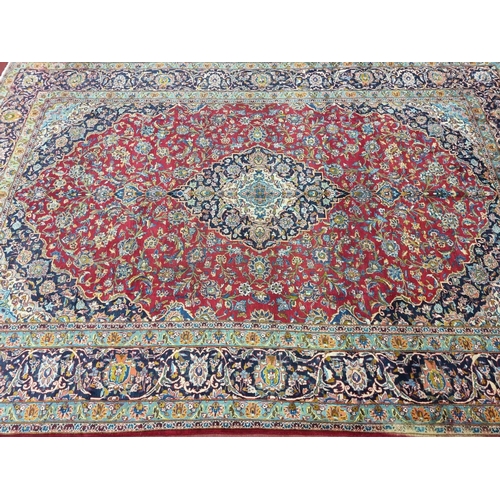 770 - A large fine woven Iranian Carpet from the Kashan region with a red field surrounded with a triple b... 